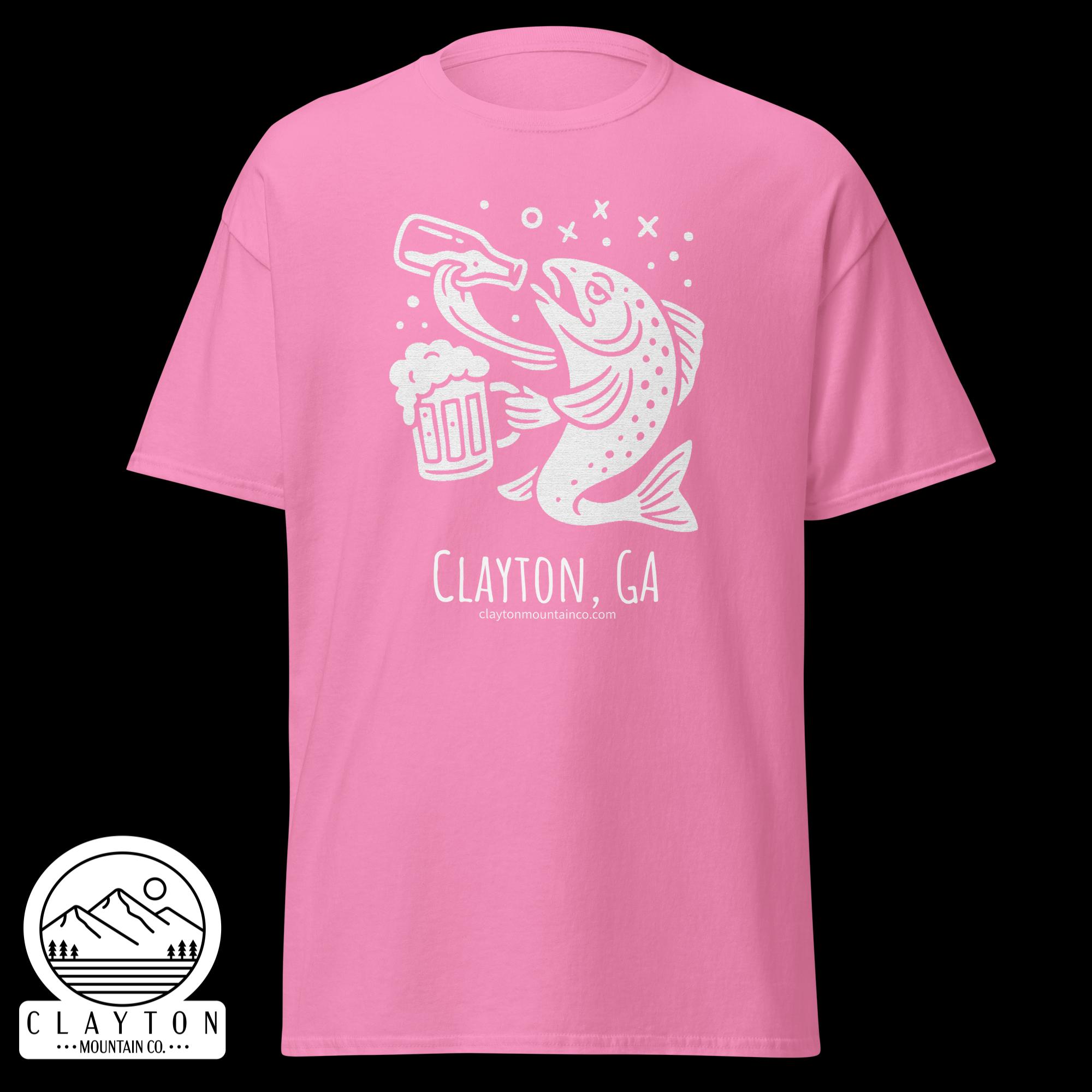 unisex-classic-tee-azalea-front-6a2e5d8991b1cjpg - Clayton Mountain Co. Pink T-shirt featuring a white graphic of a fish and beer, with 'Clayton, GA' and a small website URL visible beneath.