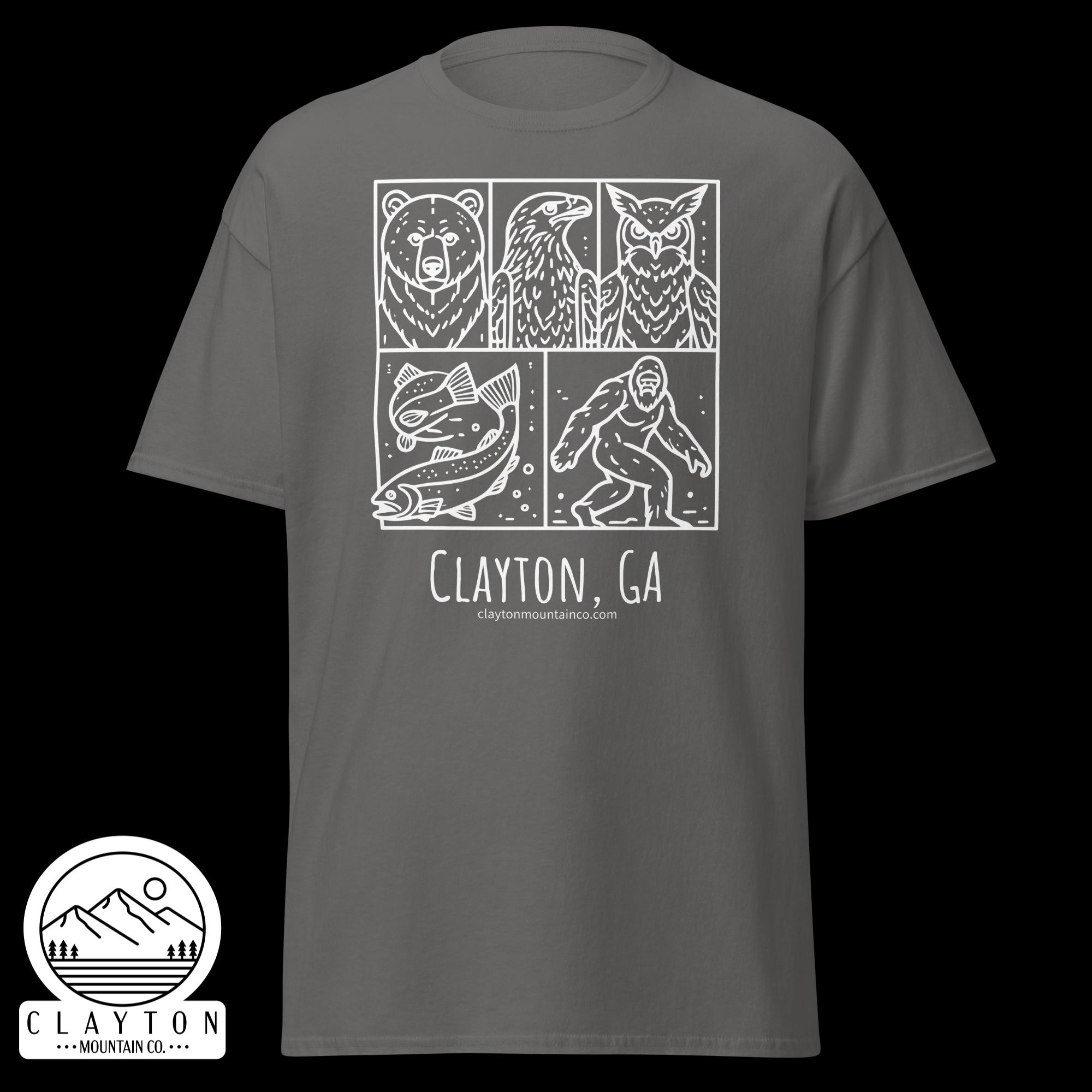 unisex-classic-tee-charcoal-front-6a2e6635a6f30jpg - Clayton Mountain Co. Gray T-shirt with white comic-panel design featuring a bear, eagle, fish, and hiker, plus 'Clayton, GA' text and mountain logo beneath.