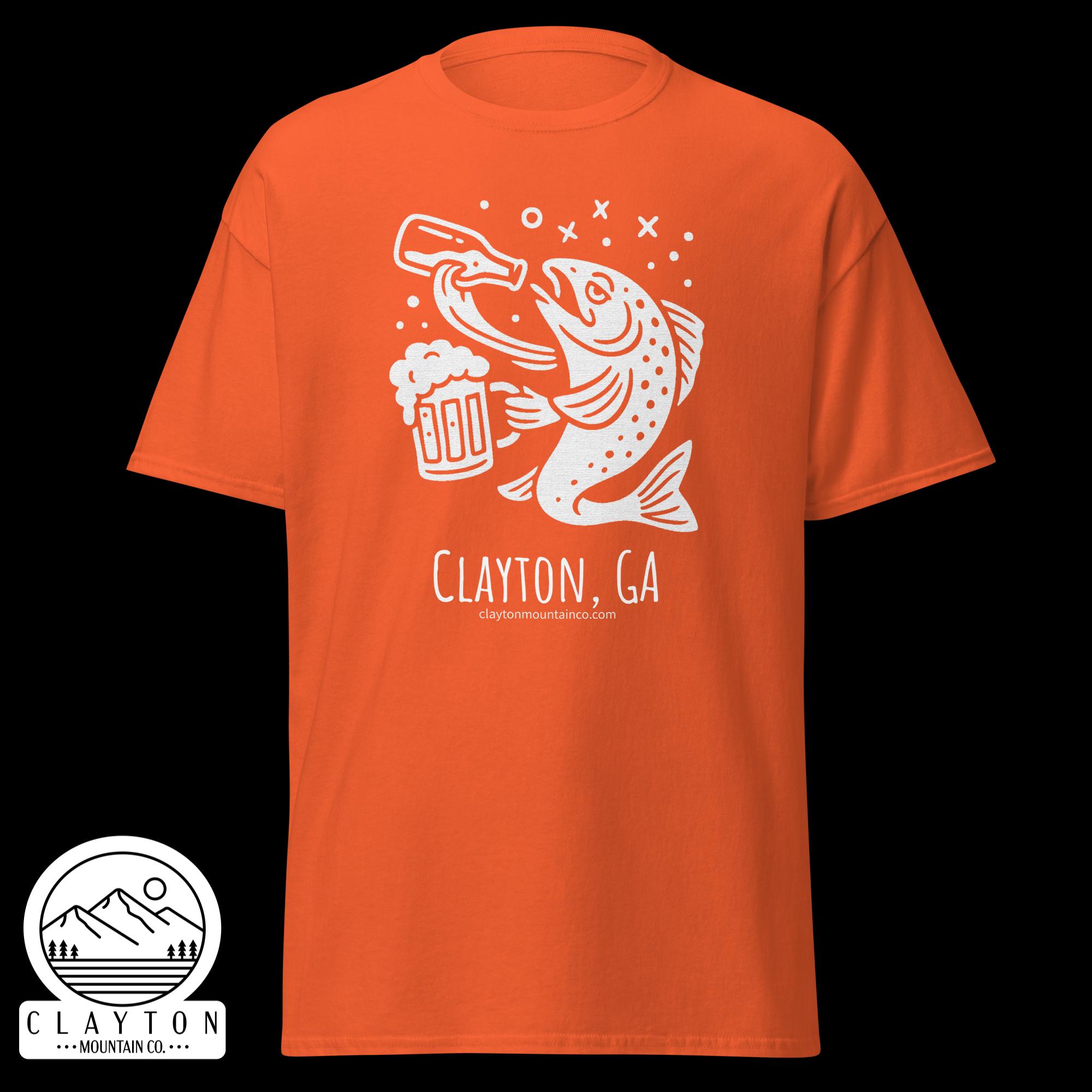 unisex-classic-tee-orange-front-6a2e5d89a6d26jpg - Clayton Mountain Co. Orange t-shirt with a white graphic of a fish catching a beer mug and Clayton Mountain Co. branding.