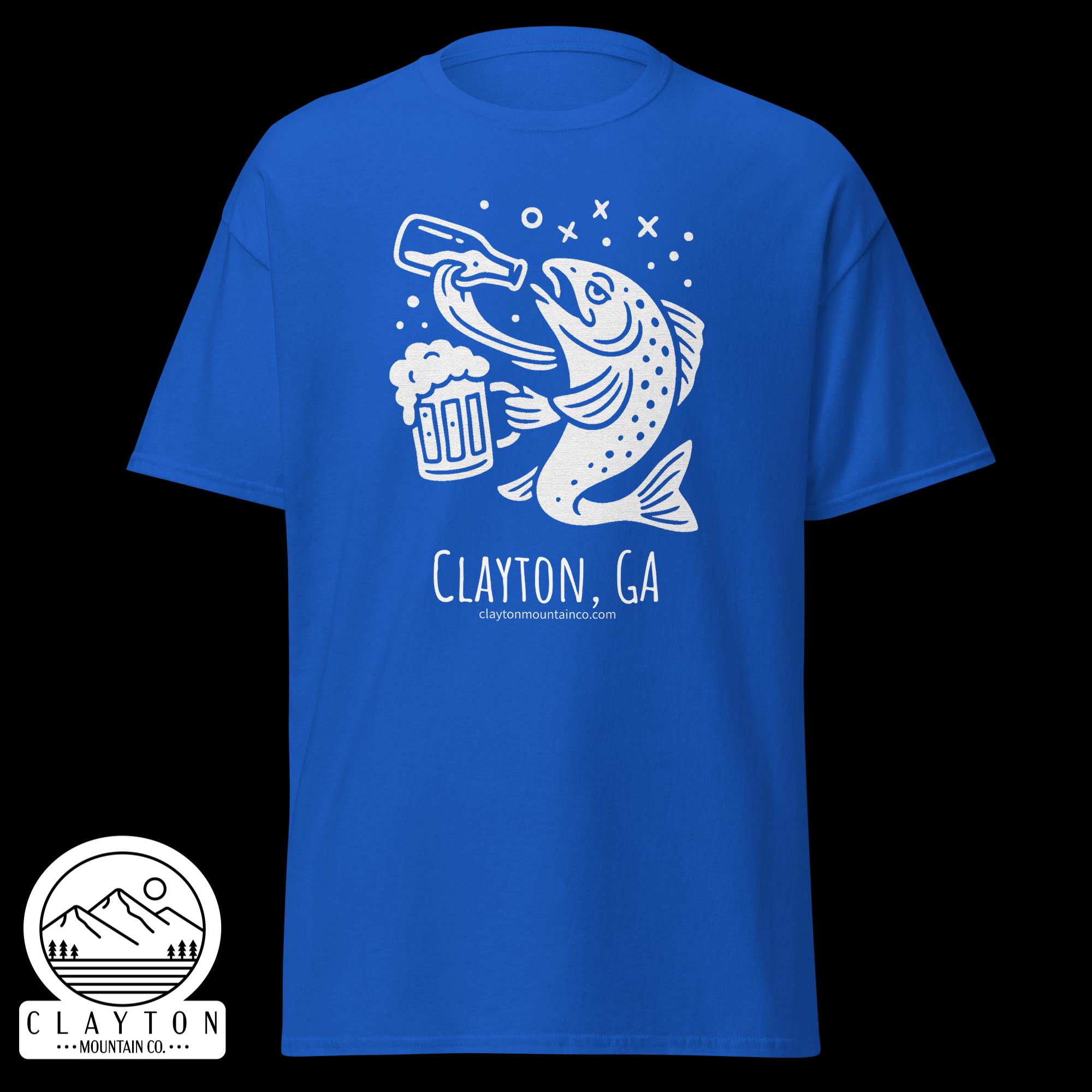 unisex-classic-tee-royal-front-6a2e5d89aae1bjpg - Clayton Mountain Co. Blue T-shirt featuring a white graphic of a fish holding a beer mug with bubbles and 'Clayton, GA' branding on the chest area.
